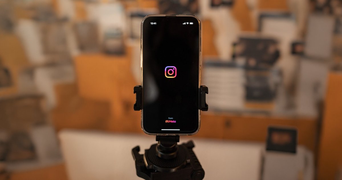 Celular em suporte de tripé exibindo a tela de abertura do aplicativo Instagram