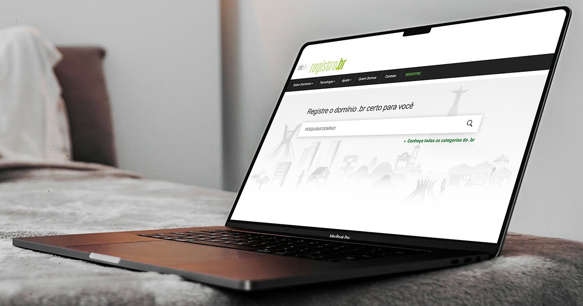 Notebook aberto sobre uma cama mostrando a página de busca de domínios do Registro.br